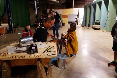 Young blacksmith at the forge making a sword