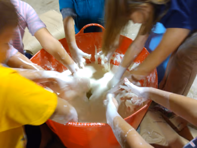 Kids plunging their hands into a big tub of oobleck