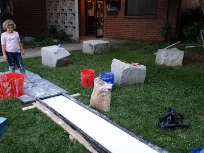 The oobleck trough setup with mixing buckets on the grass