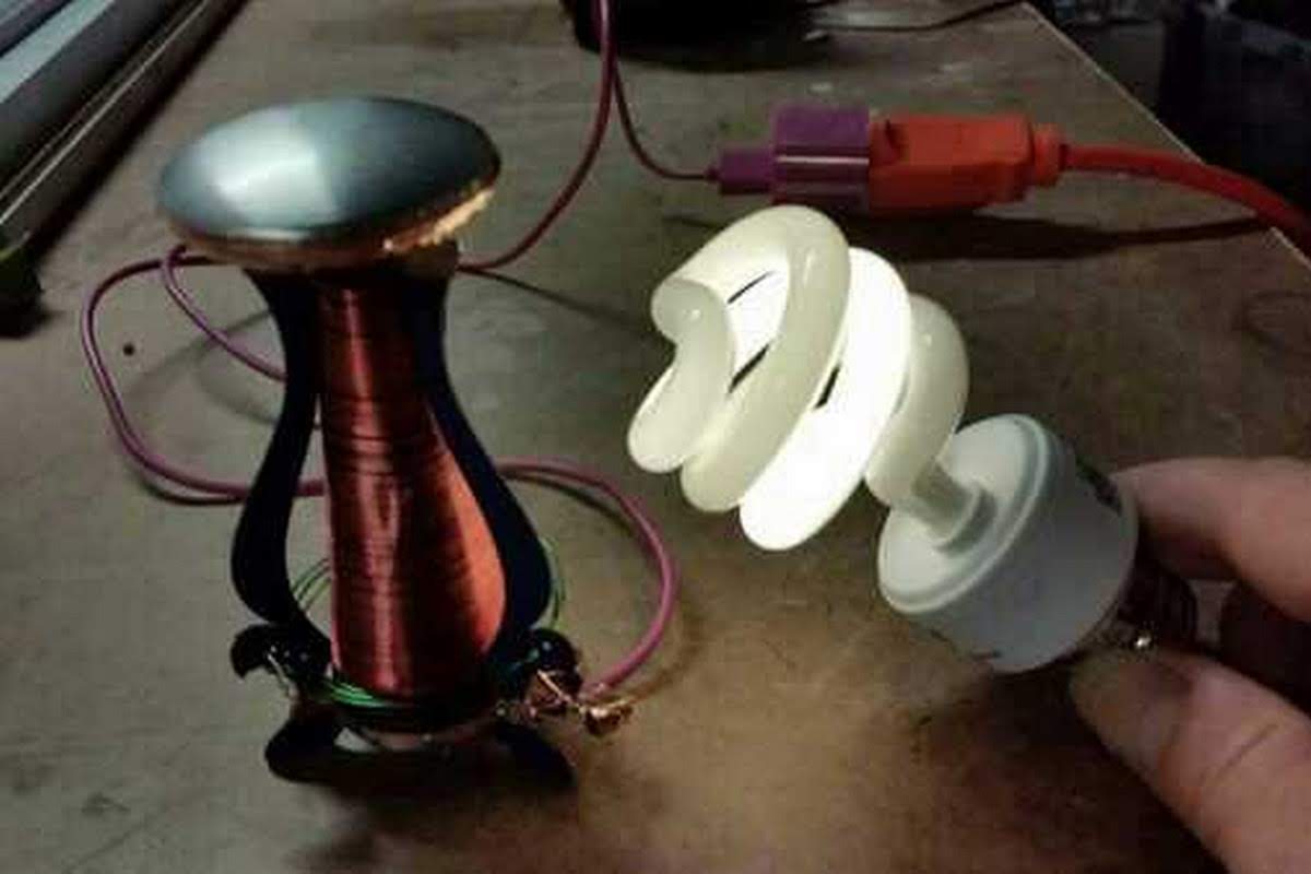 Small Tesla coil wirelessly lighting a CFL bulb, demonstrating electromagnetic induction