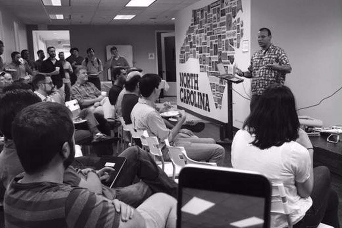 Quincy giving a tech talk presentation to a packed room at Skookum in Charlotte