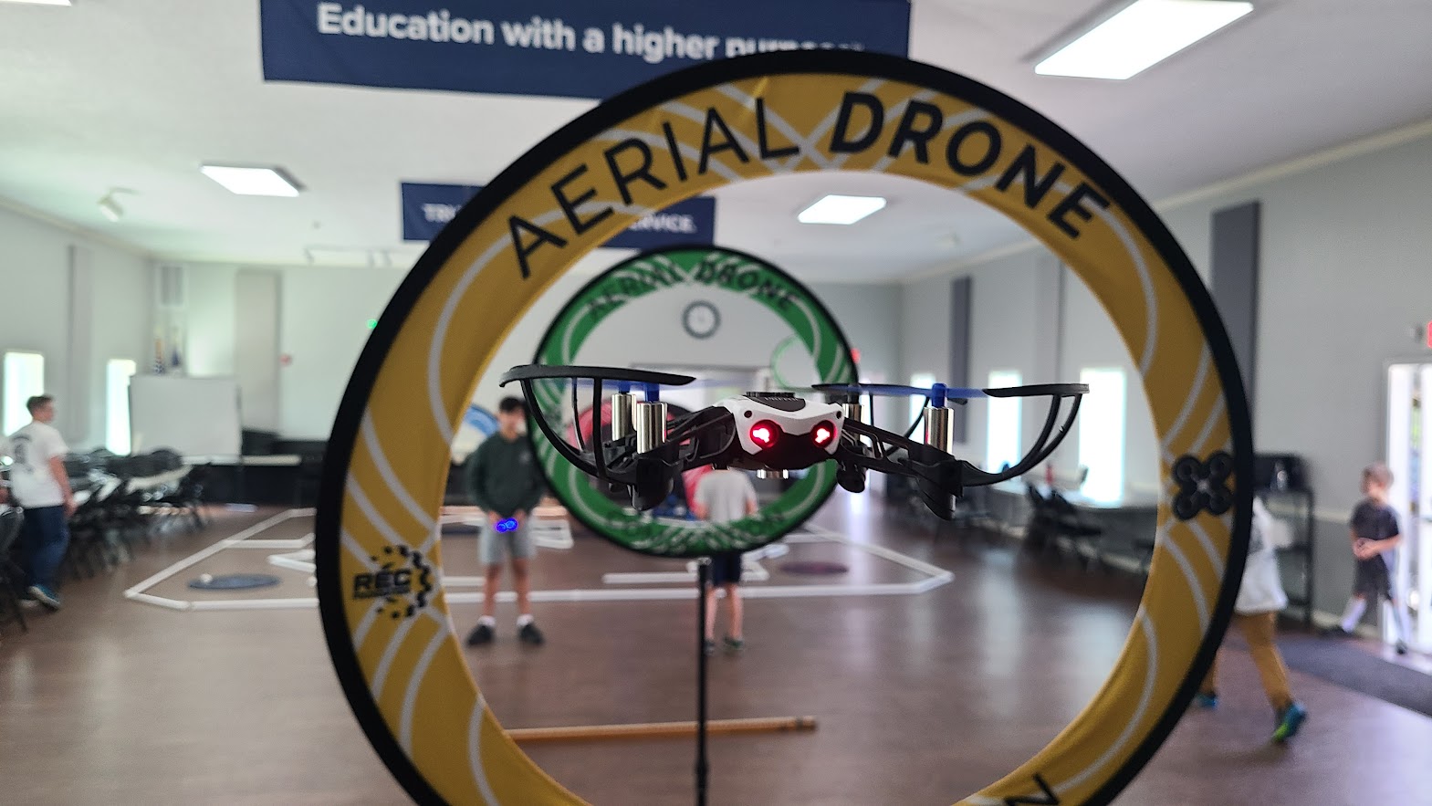 Drone flying through Aerial Drone Competition hoop