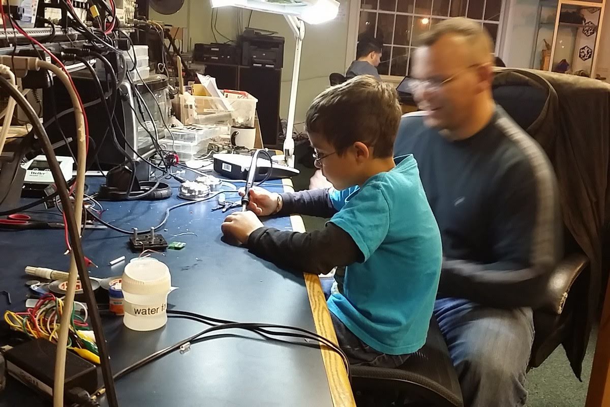 Student soldering with mentor